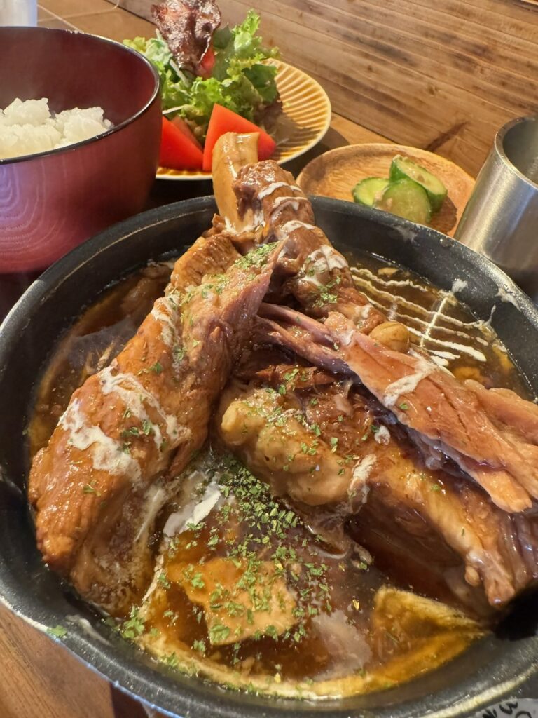 豚のスペアリブ煮込み定食のプレート。ご飯、スープ、サラダ付きでボリューム満点。