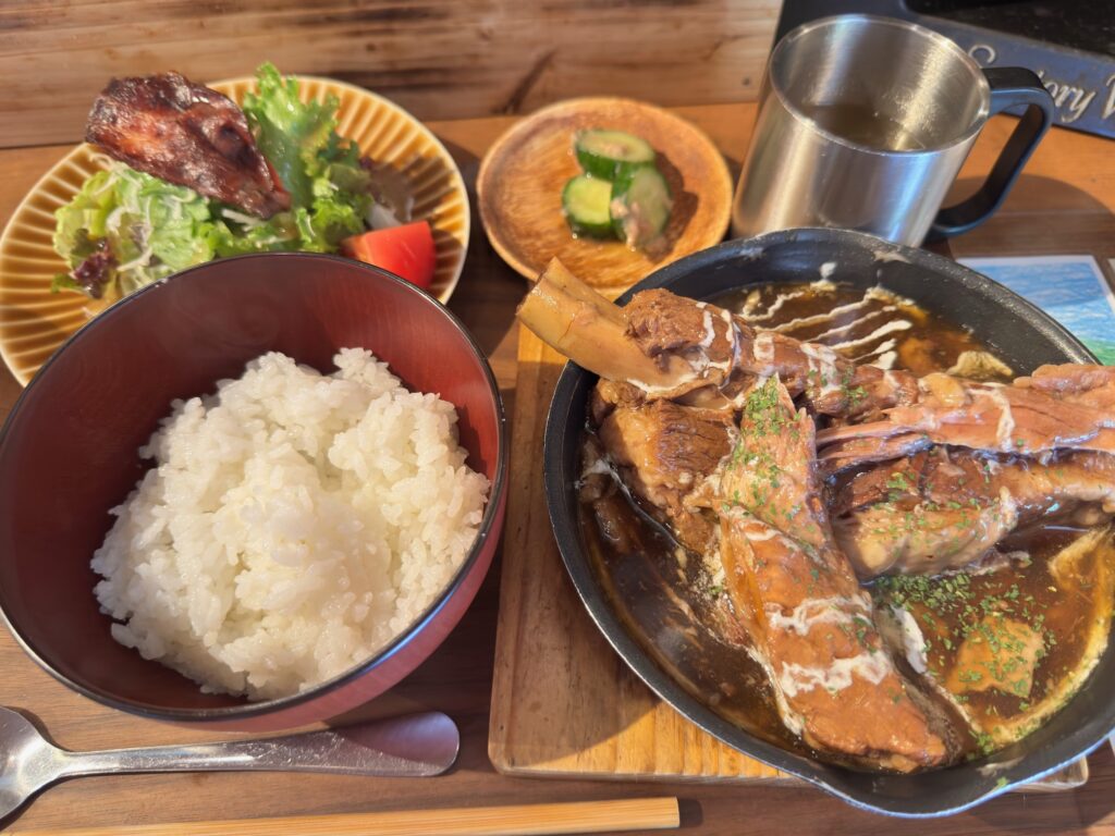 豚のスペアリブ煮込み定食のプレート。ご飯、スープ、サラダ付きでボリューム満点。