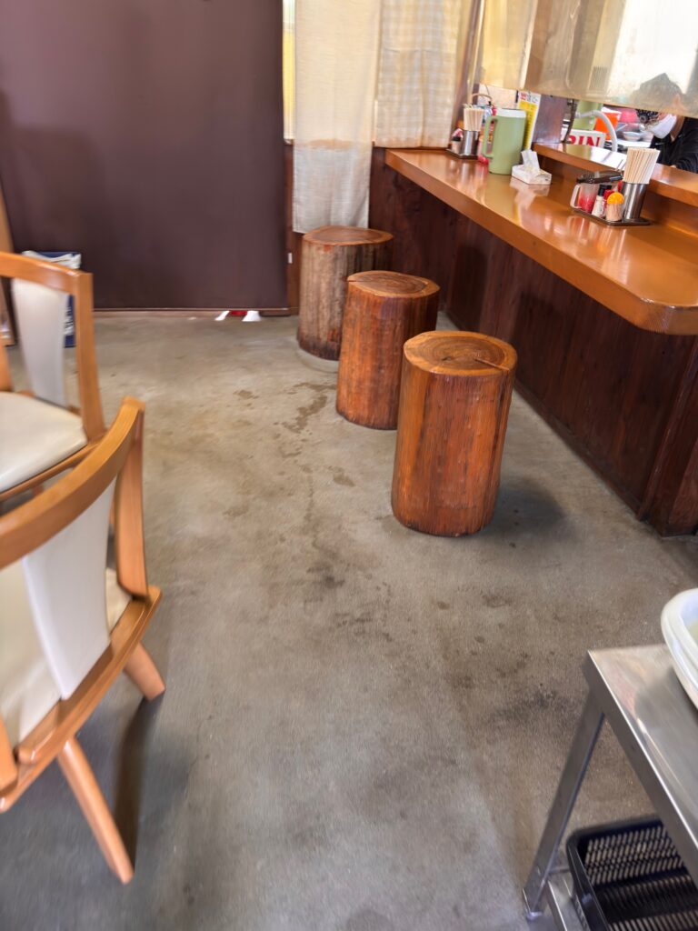 大臣閣のカウンター席と丸太椅子の店内