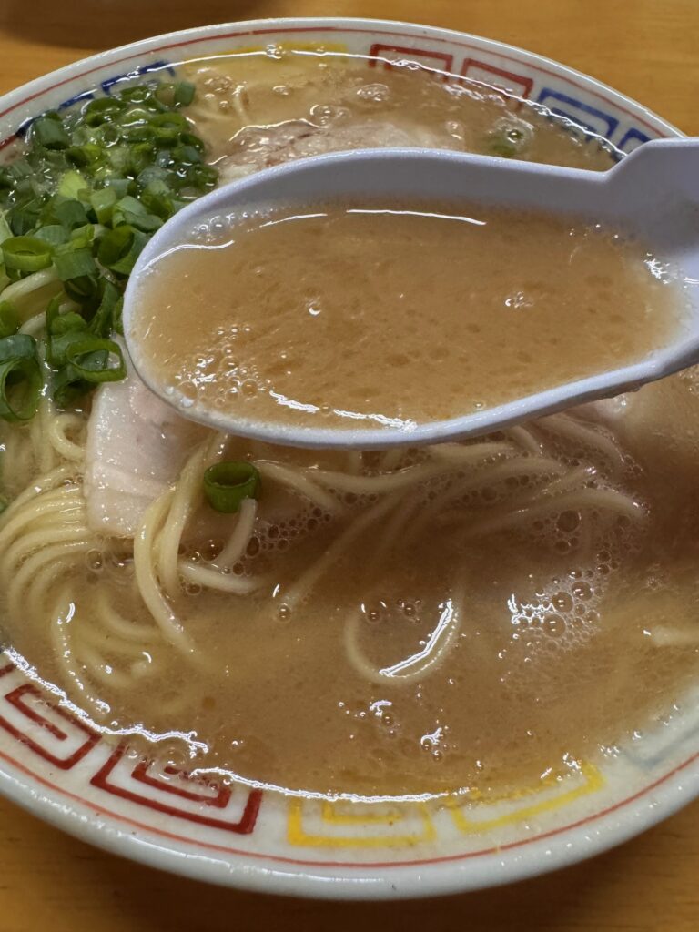 大臣閣の濃厚豚骨スープをレンゲですくったところ