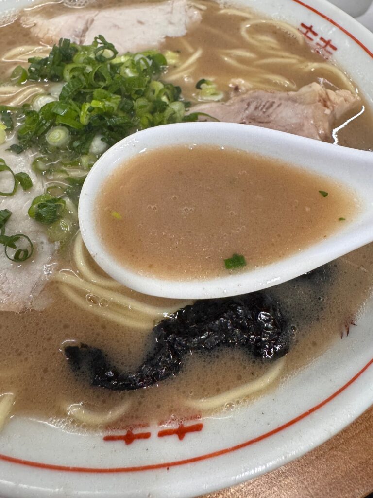 一光軒の豚骨スープをレンゲですくったところ