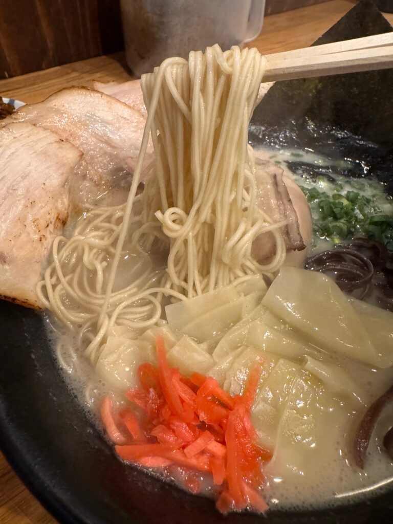 石田一龍福岡博多店の中太ストレート麺を持ち上げたところ