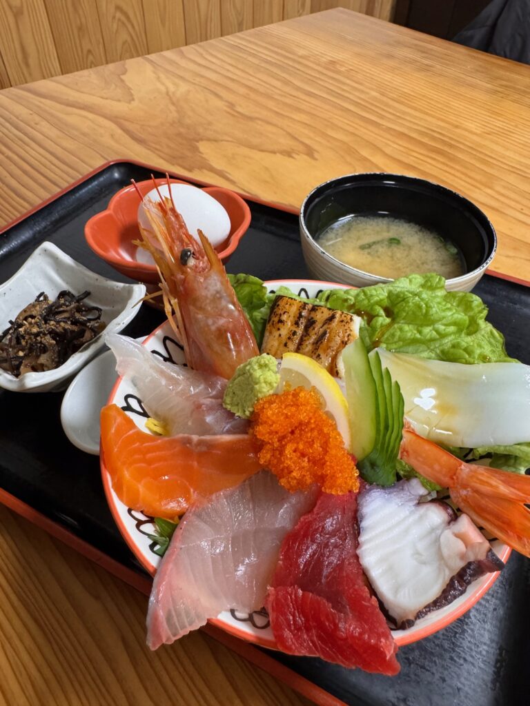 こころ食楽亭の海鮮丼（汁付き）。エビやマグロ、ブリが豪華に盛られた一杯