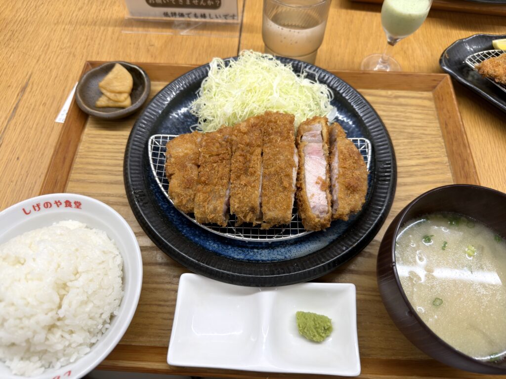 しげのや食堂の特上ロース中定食。肉厚なロースかつ、千切りキャベツ、ご飯、豚汁、漬物、わさび