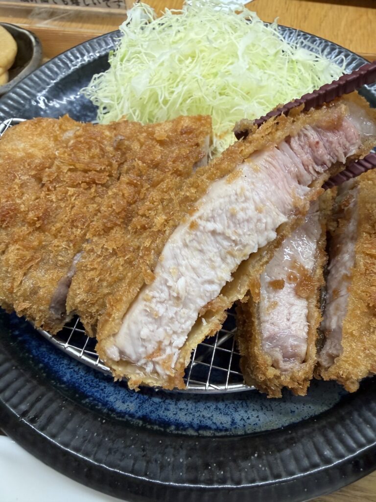 しげのや食堂の特上ロースかつのアップ。サクサクの衣に包まれた厚切りの奥豊後豚と、たっぷりの千切りキャベツ